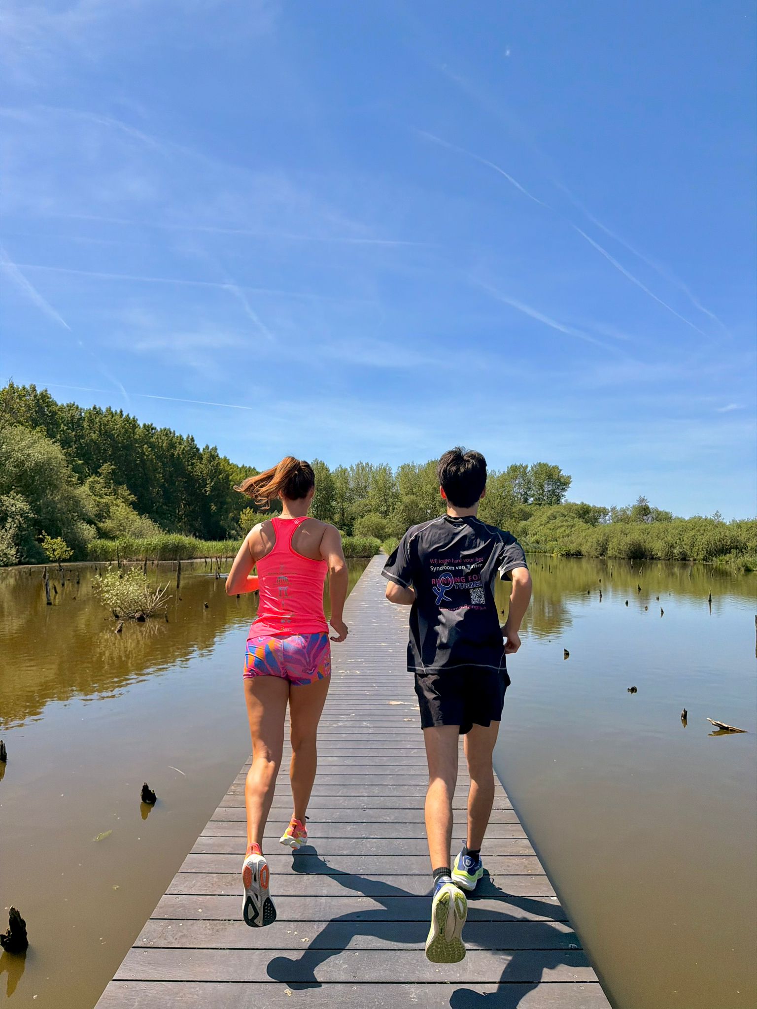Lisette en haar zoon rennen van achteren op een boardwalk over het water